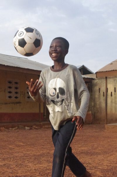 Ghanaisches Kind wirft einen Fußball